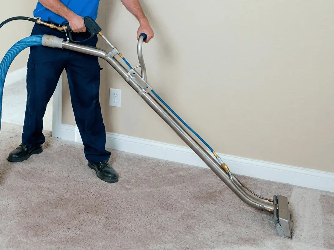 Professional operating a liquid removal machine on a carpeted floor in Detroit, MI